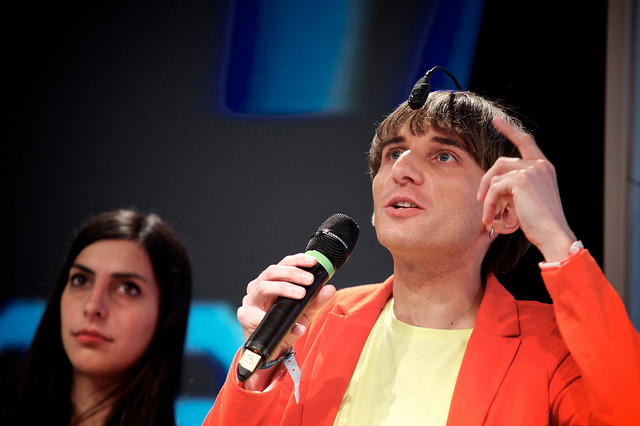 Neil Harbisson speaks with his webcam antenna on display while Moon Ribas stands nearby