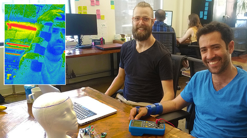 An image of two engineers at work overlaid with a heat sensor image of a man’s head
