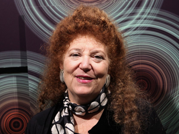 A woman with red hair against an abstract background with blue concentric cirlces