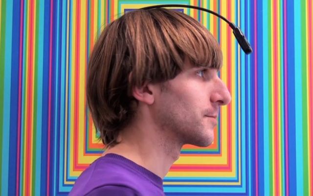 Neil Harbisson against a psychedlic color backdrop