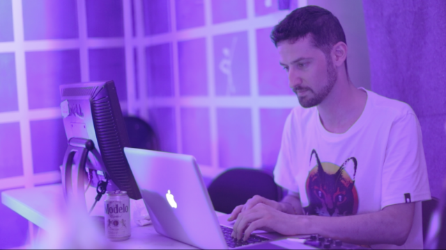 Jason Levine using a laptop in purple light