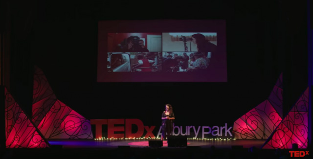 A woman on a TEDx stage