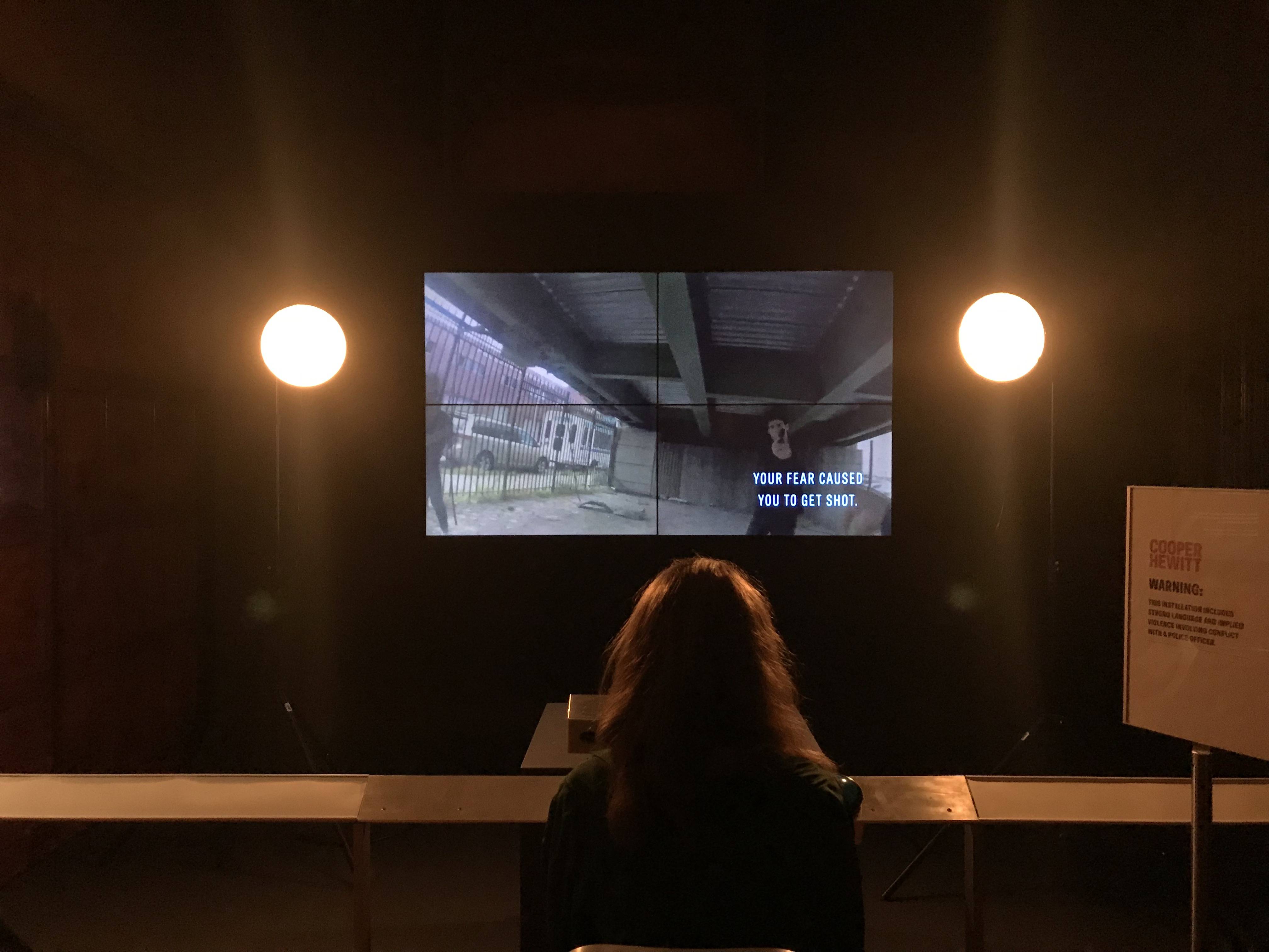A woman watching the installation in a dark room