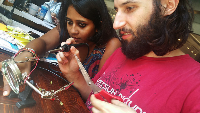 Two people using soldering equipment