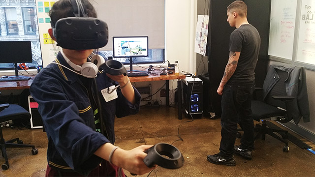 Two people using a HTC Vive headset and controller