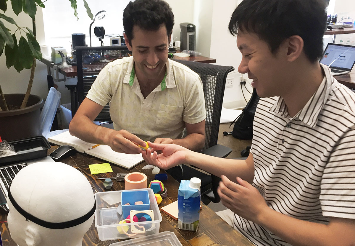 Oryan Inbar and Gary Young smiling and discussing silicon objects