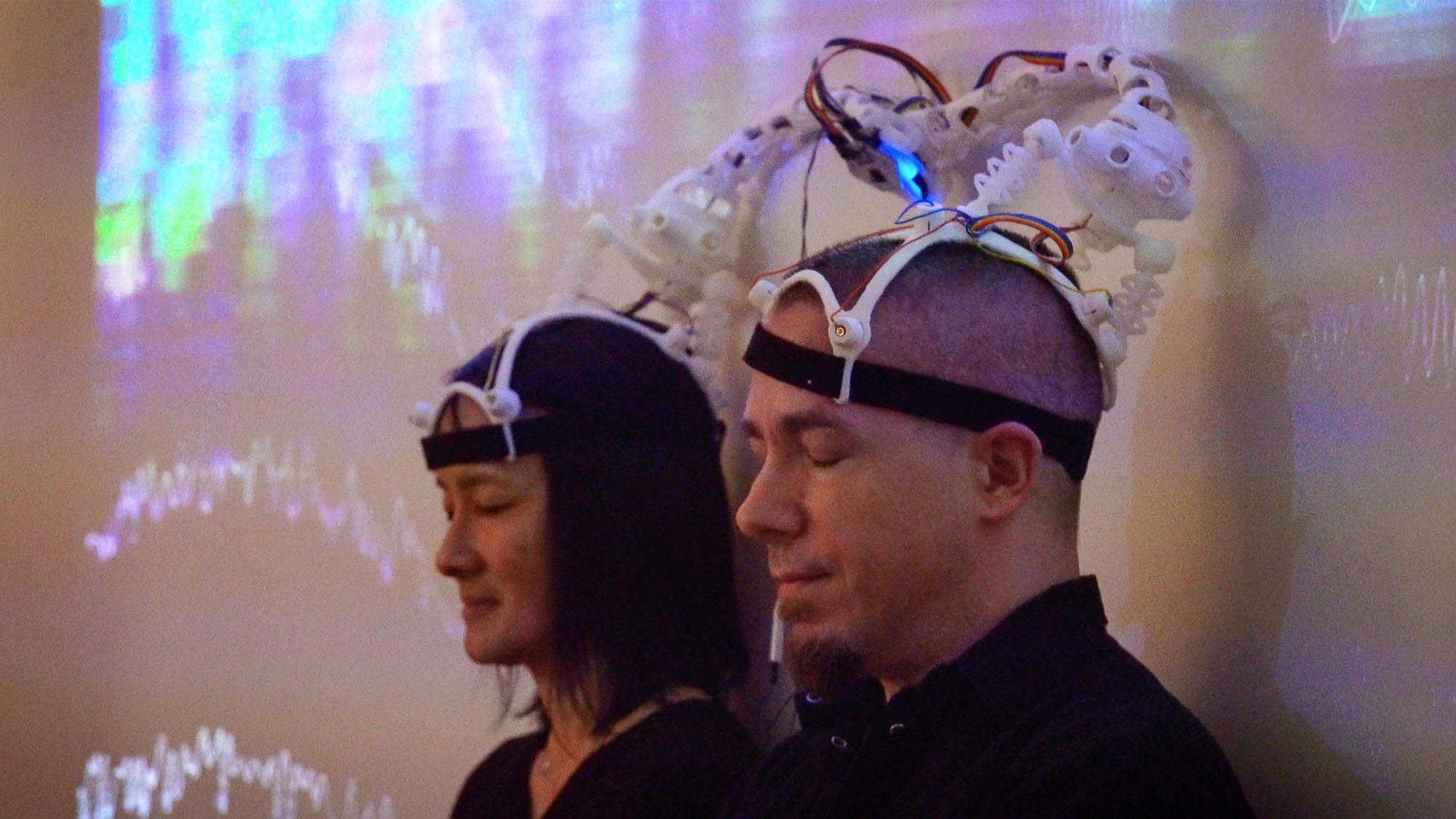 A woman and man share a custom 3D printed headset made for two