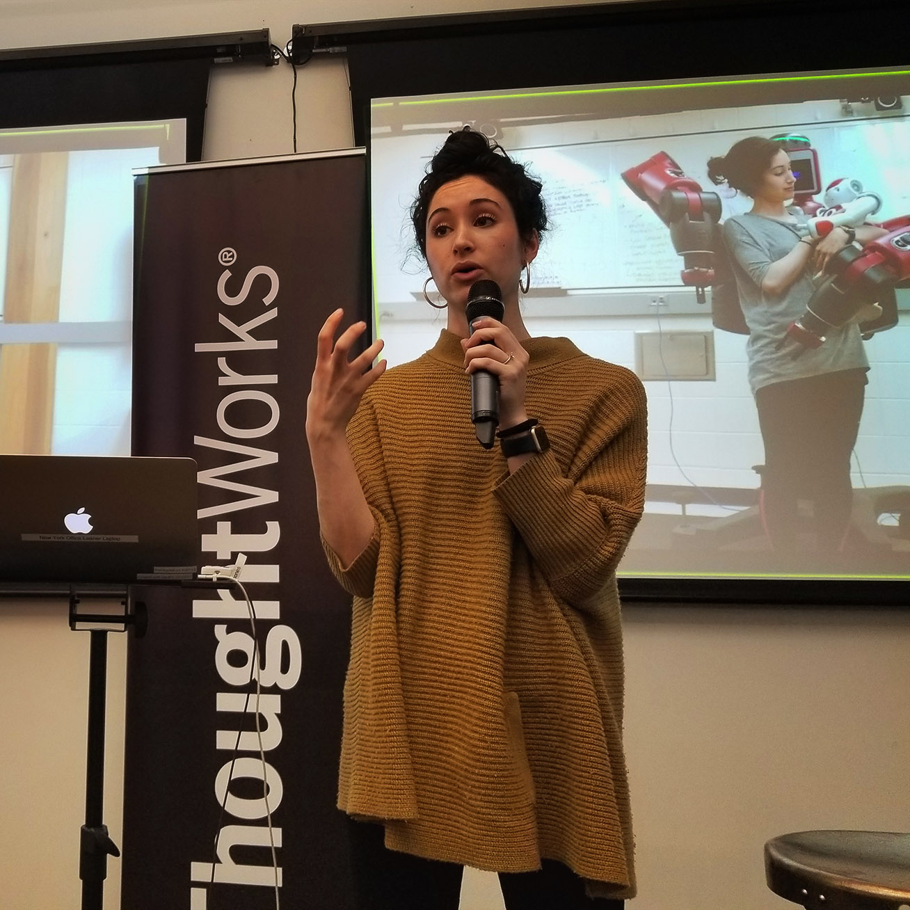 Catie Cuan holding a microphone, presenting at Thoughtworks