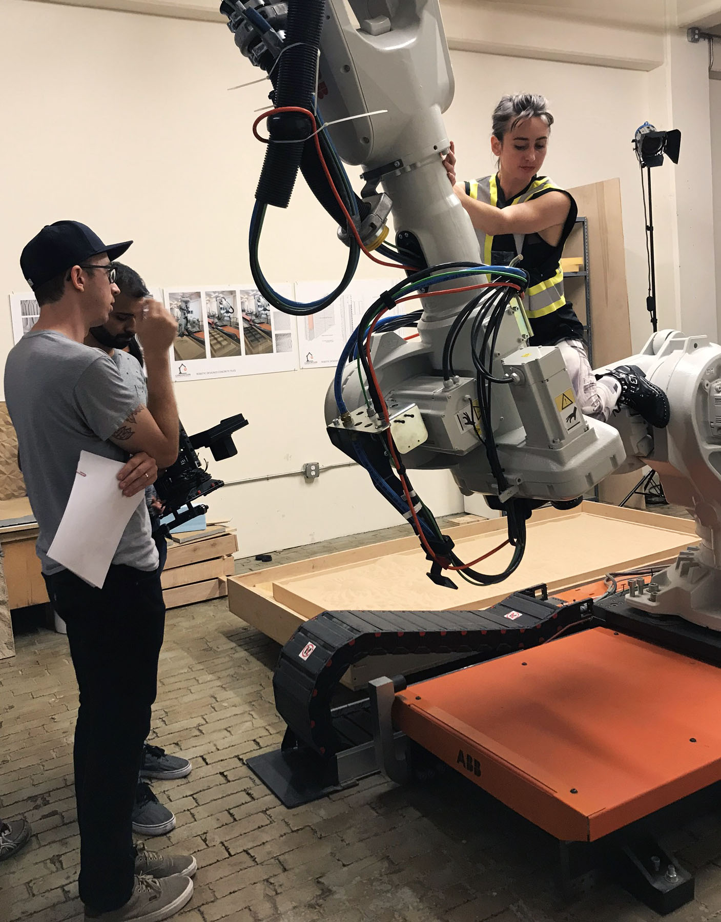 A film crew working with an industrial robot