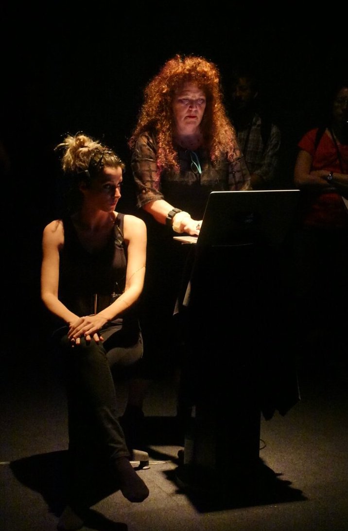 Ellen Pearlman working on a computer alongside a dancer for the Noor performance