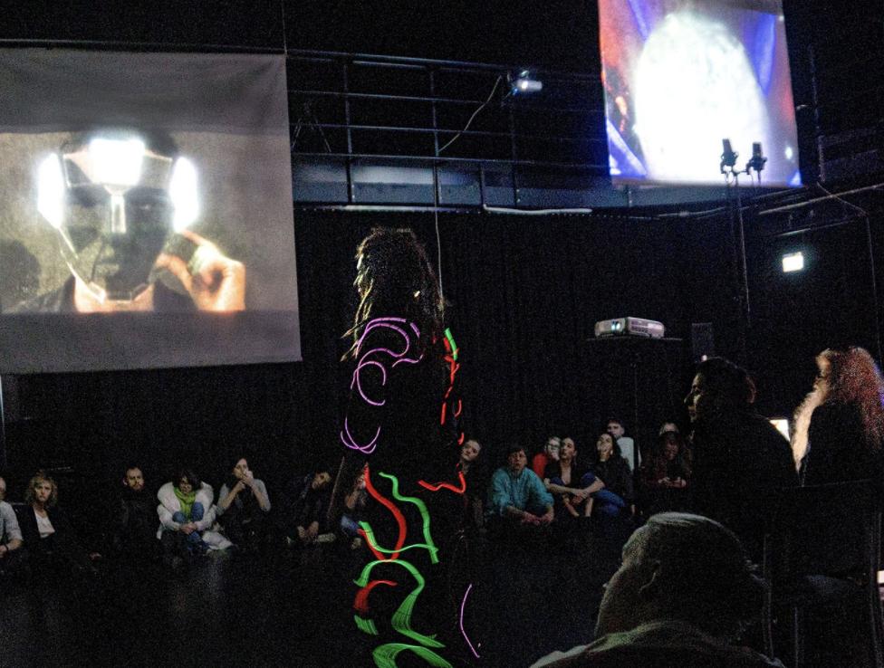 A performer wearing a suit of lights and a brainwave interface triggers colored “emotional” responses on the suit