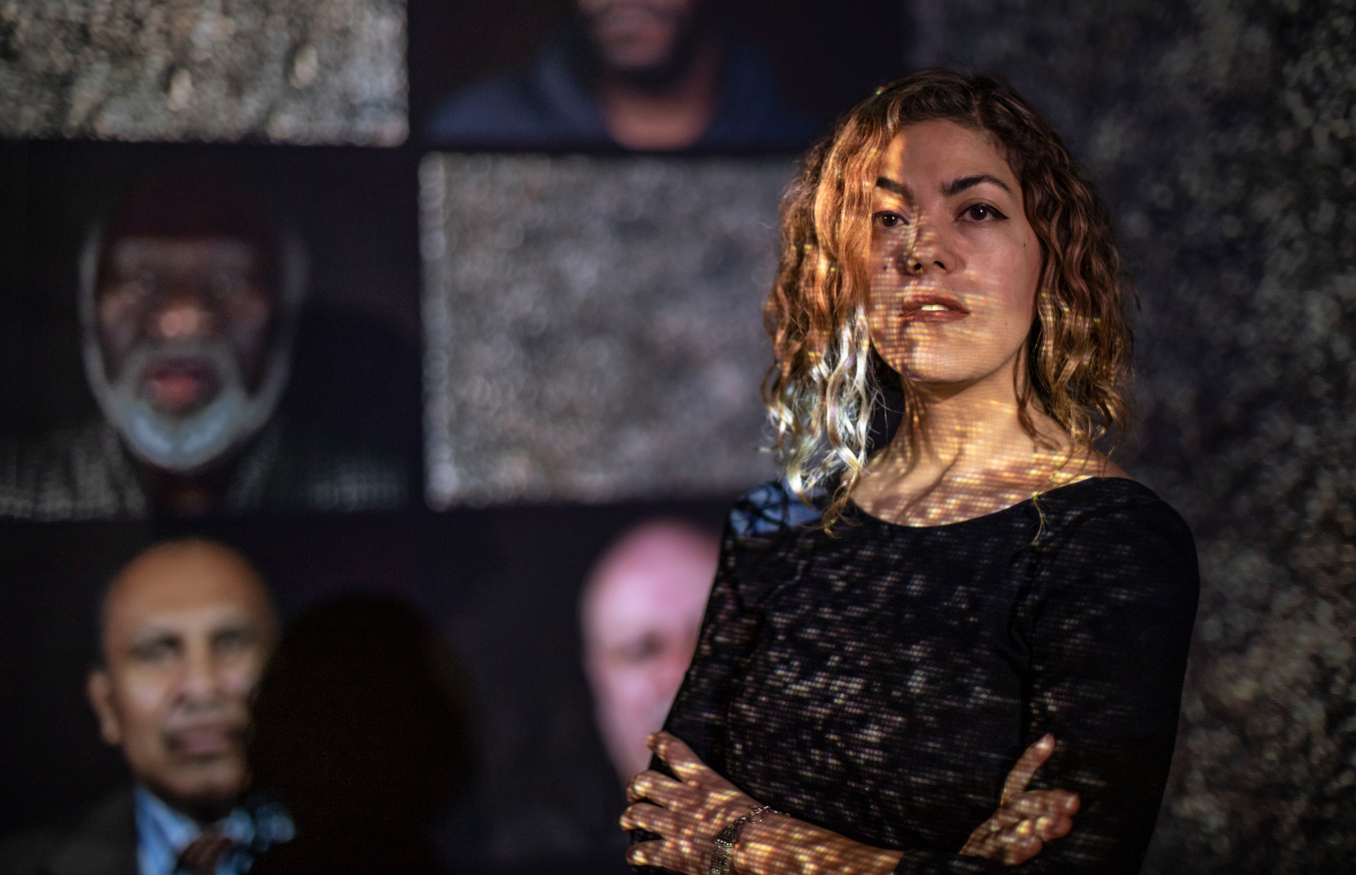 Rashin Fahandej standing in front of screens showing her work