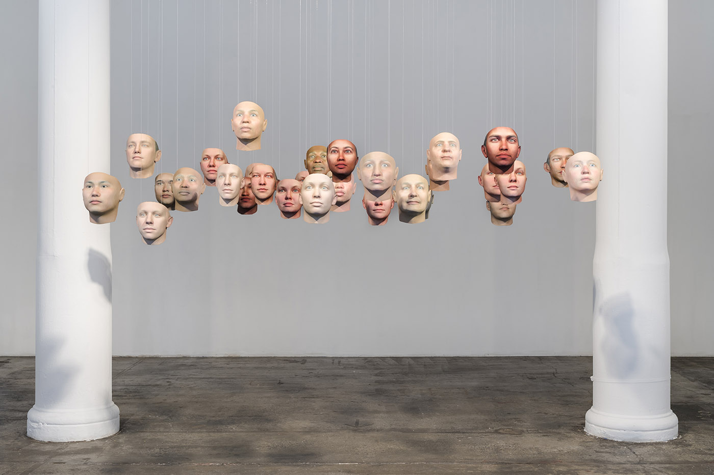 Many face masks hanging from a gallery ceiling